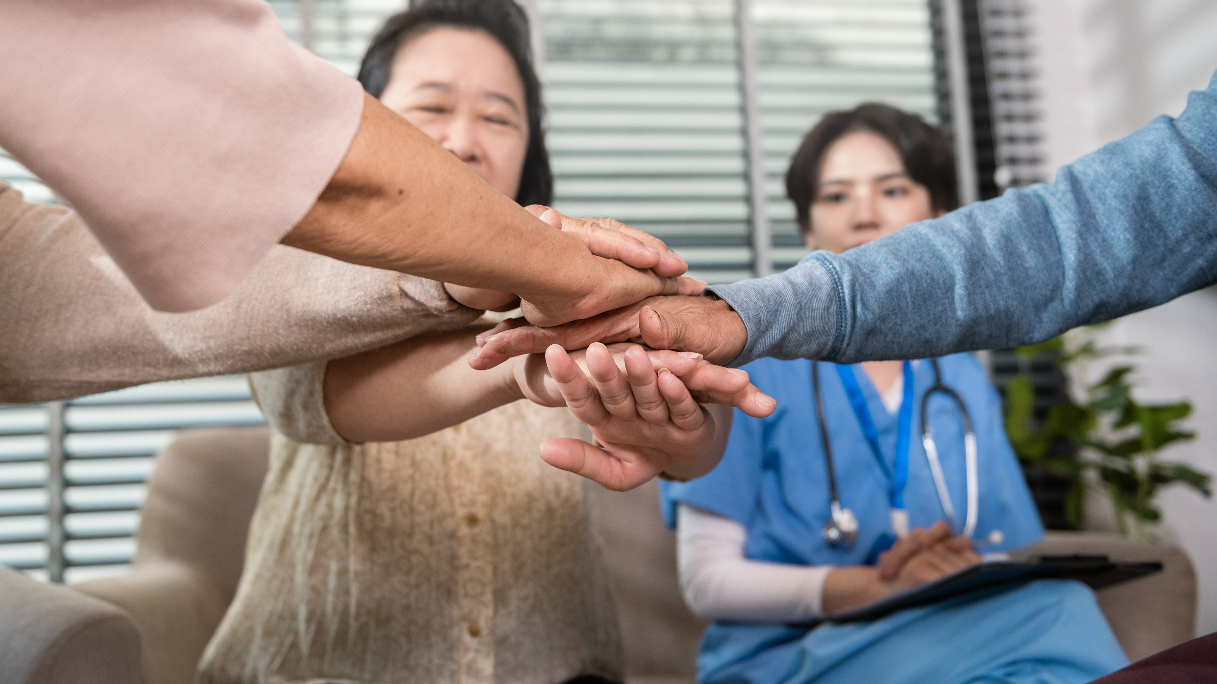 Family receiving in-home care guidance from a healthcare professional