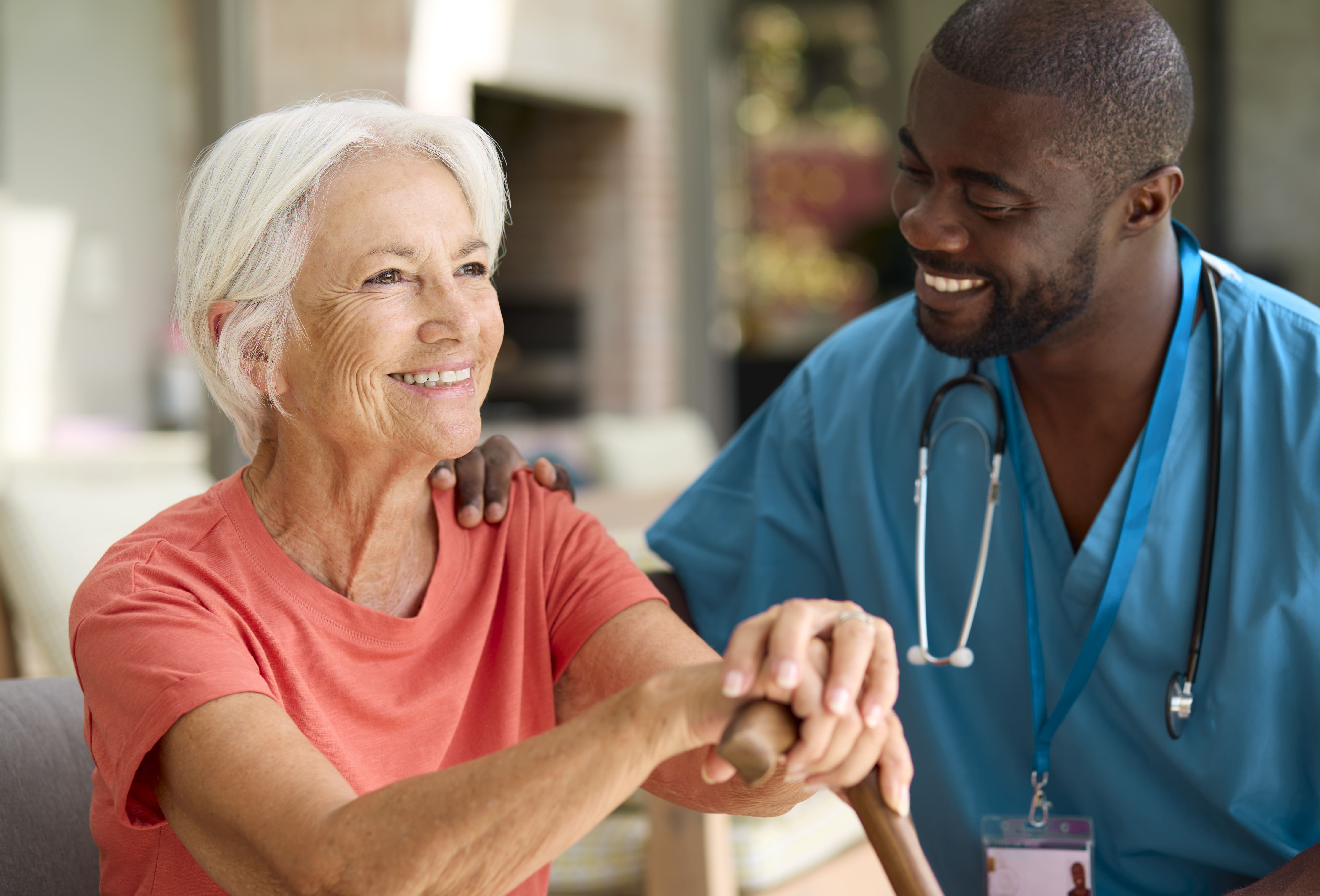 Caregiver assisting an older woman with mobility in her home